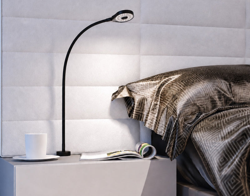 Häfele Loox black flexible LED reading light mounted on a bedside table for modern bedroom task lighting.